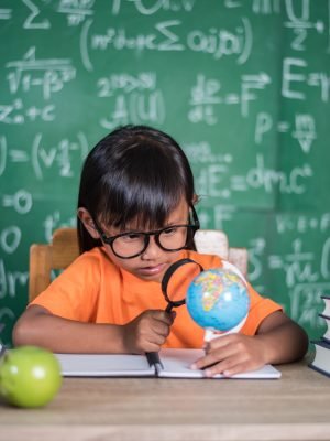 kid observing or studying educational globe model in the classr